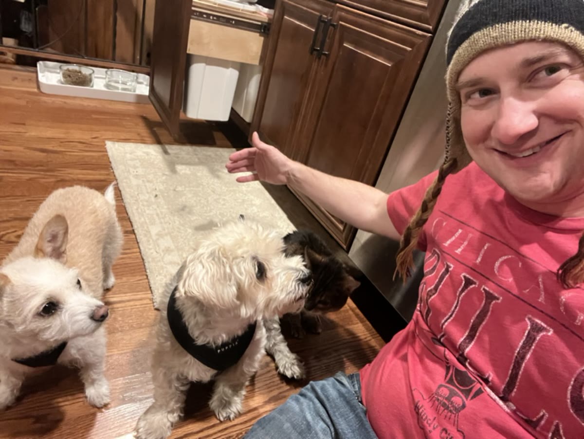 Brandon with a few dogs in a kitchen